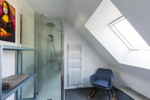 La salle de bains est pourvue d'une douche et d'une chaise bleue. dans l'établissement Maison neuve à deux pas de la plage et du GR34, à Pleubian