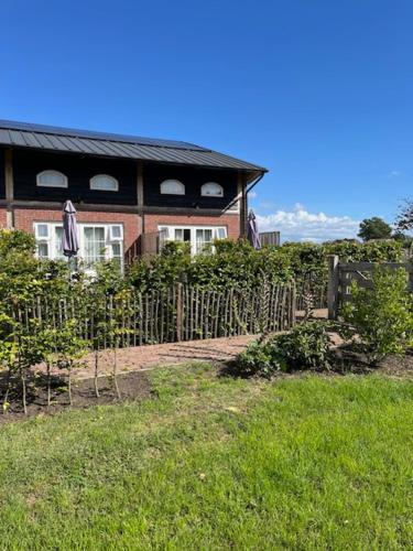 a house with a fence in front of it at De Citadel - De Boomgaard in Markelo