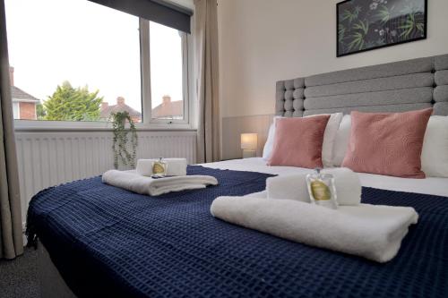 a bedroom with a bed with towels on it at Beech Palace - Stylish 3Bed Home with Private Garden, Free Parking & Netflix in Coventry