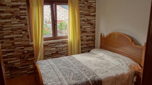 a bedroom with a bed and a window with yellow curtains at Casa Ardora - Playa de Carnota in San Mamede de Carnota