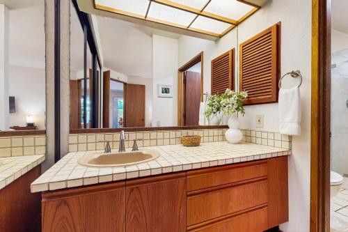 a bathroom with a sink and a mirror at Tropical Getaway at the Shores Waikoloa Beach #138 in Waikoloa