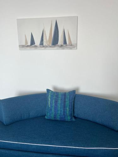 a blue couch with a painting of sail boats at Hotel Il Gabbiano in Positano