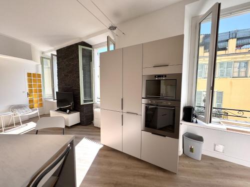 une cuisine avec des placards blancs et une grande fenêtre dans l'établissement CC OT L atelier du Collet OLD Town Promenade des anglais, à Nice