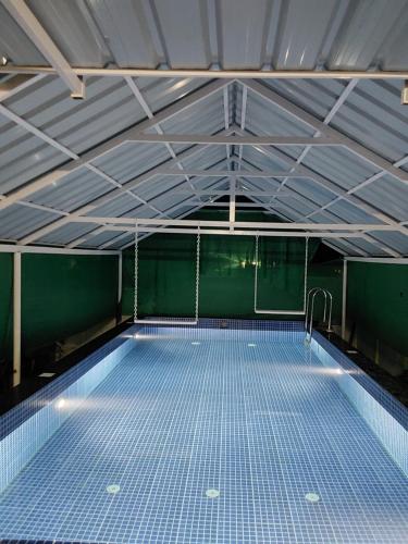 una piscina con pavimenti in piastrelle blu in un edificio di Johnson's Homestay With Pool & Ecohouseboat near town beach a Alleppey