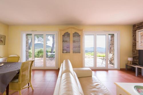 un salon avec une table, des chaises et des fenêtres dans l'établissement Villa, 3 chambres ,vue mer, jacuzzi, à Carqueiranne