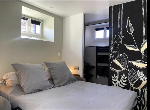 - une chambre avec un lit et un mur noir et blanc dans l'établissement Élégance - Détente -Nature & Jacuzzi, à Allauch