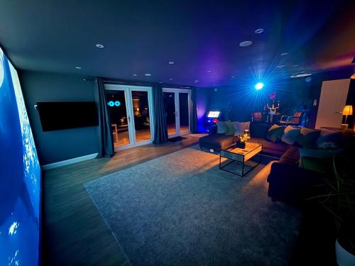 a living room with a couch and a table at Sunridge Fishing Lodge with Hot Tub & Giant Cinema in Plymouth