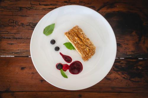 a white plate with food on a wooden table at Cava Colchagua Hotel Boutique in Santa Cruz