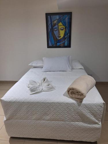 a white bed with a towel on top of it at Apartahotel del Paseo in San José