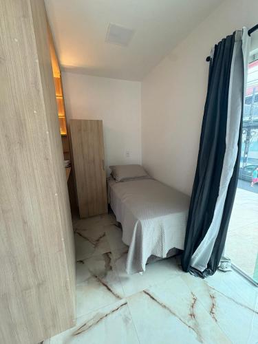 a small bedroom with a bed and a window at Morada Manaus in Manaus