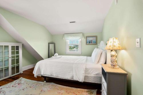 a bedroom with a white bed and a window at Waterfront Walk to Beach in Barnstable