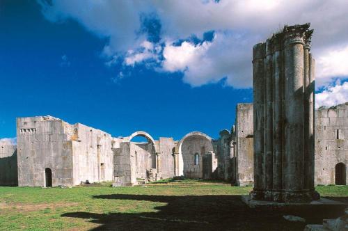 an old building with a pillar in a field at Miky M House in Venosa