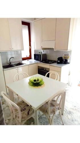 a white kitchen with a white table and chairs at Miky M House in Venosa