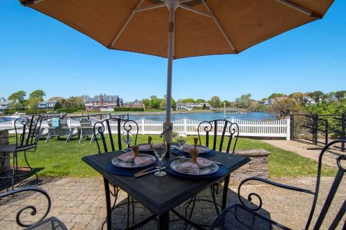 a black table with chairs and an umbrella at Waterfront Walk to Beach in Barnstable