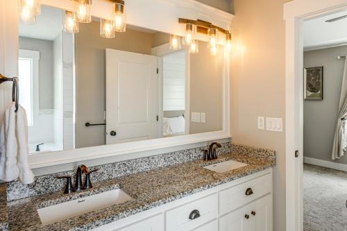 a bathroom with two sinks and a large mirror at 4 Mi to Snake River Family Home with Yard in Rigby in Rigby