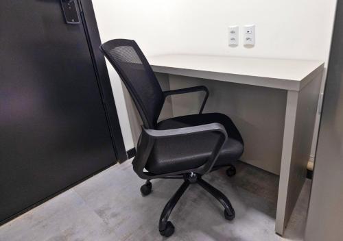 a black chair sitting in front of a desk at Urbà Home Stay by Housi in Goiânia