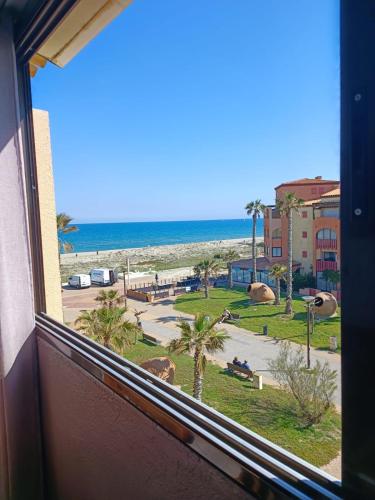 - une fenêtre avec vue sur la plage et l'océan dans l'établissement DUPLEX front de mer, au Barcarès