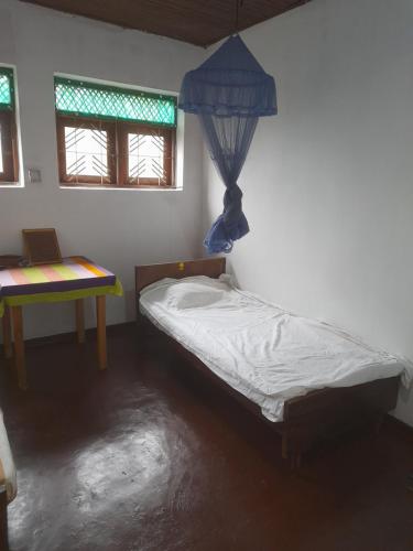 a small bedroom with a bed and a table at New Born Restaurant & Accommodation in Hikkaduwa