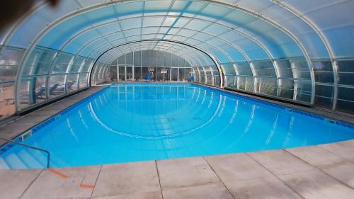 une piscine intérieure avec un plafond en verre dans l'établissement 2 étoiles - Résidence Loisirs, à Saint-Pierre-dʼOléron