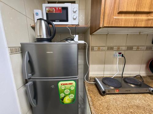 a kitchen counter with a refrigerator and a microwave at Large Studio Apartment for 4 in Sharjah