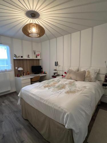 une chambre avec un grand lit blanc avec un plafond dans l'établissement Appartement calme avec vue lac, à Excenevex