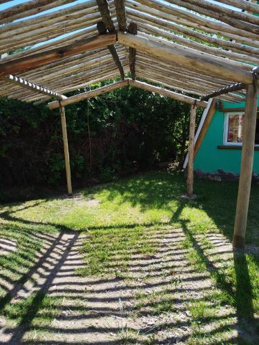 a wooden pergola in front of a house at Complejo de Cabañas Tierra de Luna in Potrerillos