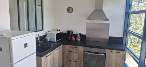 une cuisine avec un évier et un micro-ondes dans l'établissement Appartement 2 chambres proche mer et centre ville, à Bretignolles-sur-Mer