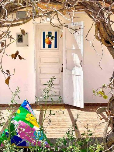 a door to a house with a colorful umbrella next to it at Idyllic, Charming Quinta das Laranjeiras in Alcácer do Sal
