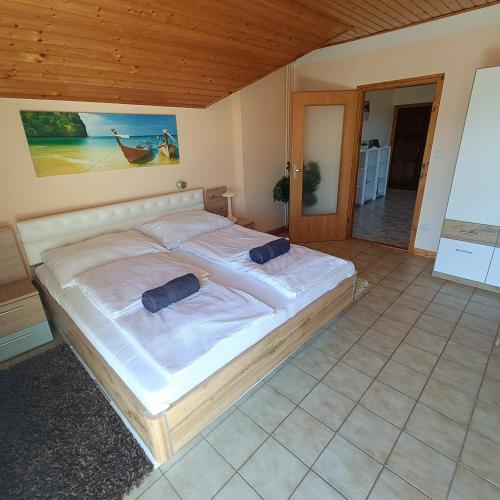 a large bed in a bedroom with a wooden ceiling at Villa Mátis in Balatonederics