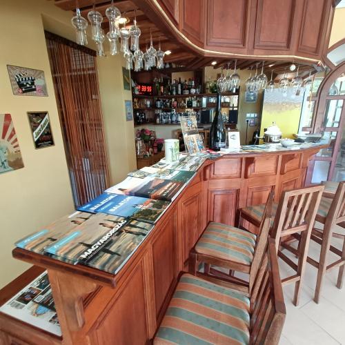 a kitchen with a bar with wooden cabinets and chairs at Villa Mátis in Balatonederics