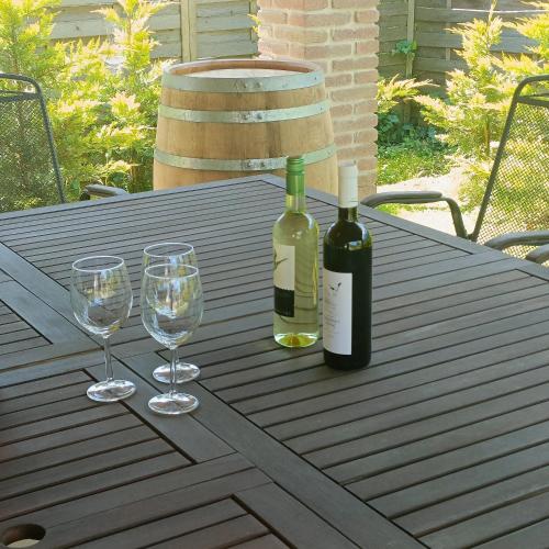 a table with two bottles of wine and two glasses at Villa Mátis in Balatonederics