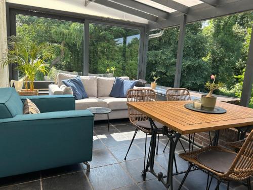 a patio with a couch and a table and chairs at Vakantiewoning Hoogveld in Kortessem