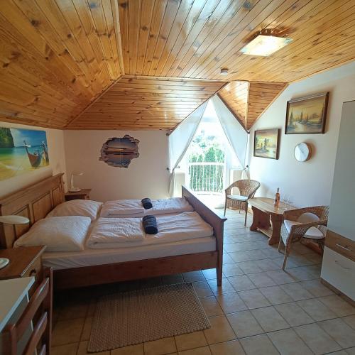 a bedroom with a large bed with a wooden ceiling at Villa Mátis in Balatonederics