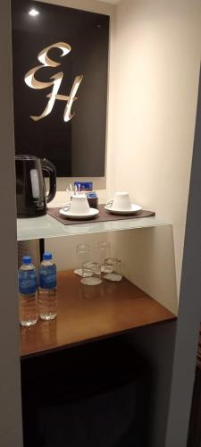 a shelf with bottles of water and a sink at Elegance Hotel in Tres Arroyos
