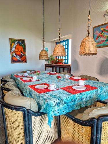 een tafel met stoelen en een blauwe tafeldoek bij Nossa Casa Maracaipe in Porto De Galinhas