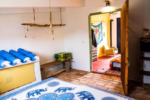 a bedroom with a bed and a door to a room at WILDSPIRIT Bedroom in Permaculture Paradise at WILDSPIRIT Eco Cultural Farm in Villanueva de Alcolea