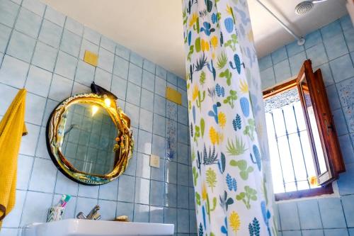 a bathroom with a mirror and a sink and a shower curtain at WILDSPIRIT Bedroom in Permaculture Paradise at WILDSPIRIT Eco Cultural Farm in Villanueva de Alcolea