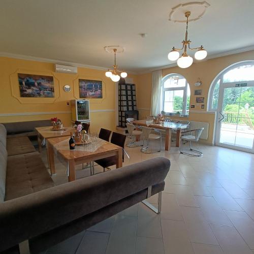 a living room with a couch and tables and chairs at Villa Mátis in Balatonederics