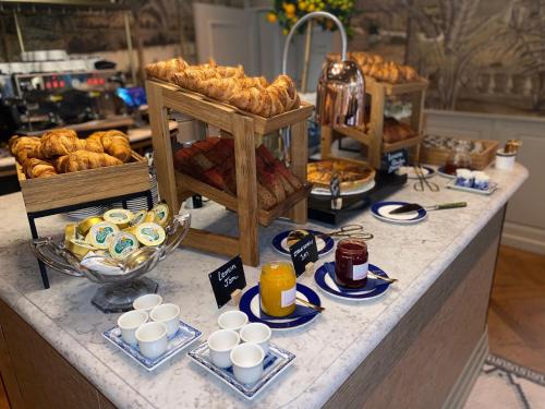a buffet with pastries and cups of coffee and bread at Hotel 717 in Amsterdam
