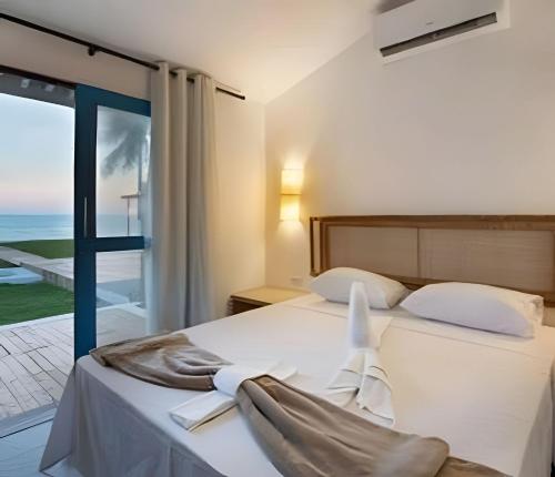 a bedroom with a bed with a view of the ocean at Pousada - Nossa Casa Maracaipe in Porto De Galinhas