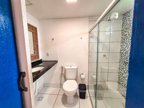 a bathroom with a toilet and a glass shower at Nossa Casa Maracaipe in Porto De Galinhas