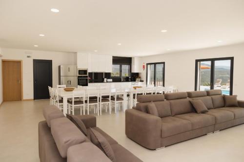 a large living room with a couch and a kitchen at Casa do Tojo (Camélias de Basto - Turismo Rural) in Pedras Alvas