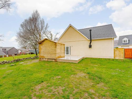 a house with a wooden shed in a yard at 4 Bed in Penygroes 86423 in Pen-y-groes