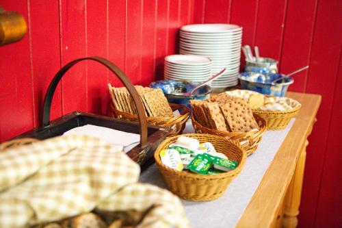 a table with baskets of bread and plates on it at Ullensvang Gjesteheim in Lofthus