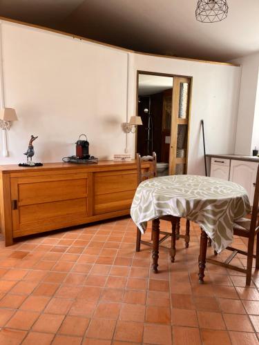 a living room with a table and a kitchen at La Mignonnerie in La Marne