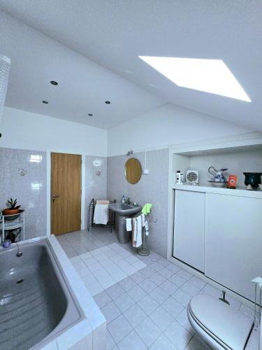 a large bathroom with a tub and a sink at Bulle Entre Parenthèses in Aroeira