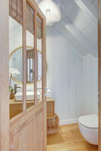 a bathroom with a toilet and a mirror at Villa de l'Herbe , Cap Ferret in Cap-Ferret
