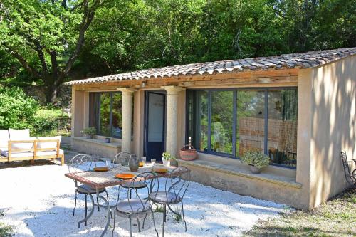 une table et des chaises devant une maison dans l'établissement Les Restanques de la Baucoué - Dépendance, à Roquevaire
