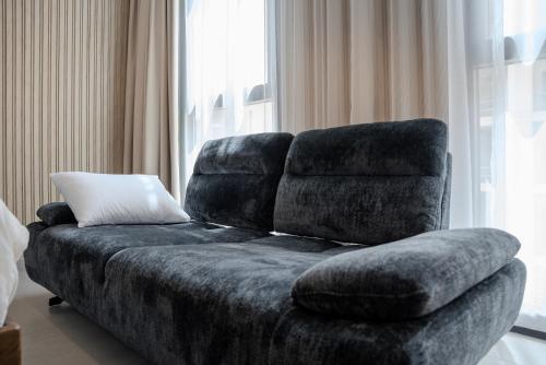un sofá sentado frente a una ventana en Private Luxury Home Sleeps 3 Pool Access, en Sharjah Intl