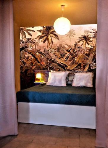 Ce lit se trouve dans un dortoir orné d'une fresque murale. dans l'établissement Le Studio la Petite Colline à Céret, à Céret